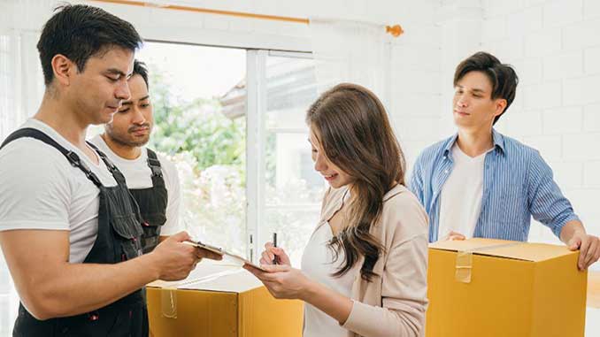 A couple signing an agreement with movers